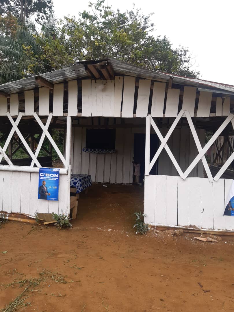 The village shop at Ntann — a white-painted wooden structure on red earth.