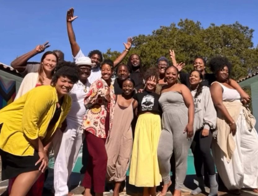 Cohort of the Psychedelic Leadership Retreat gathered outdoors in the Oakland Hills, hands raised in celebration.